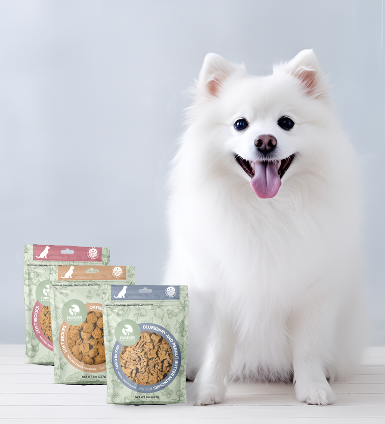 a white pomeranian dog sitting next to a bag of dog treats